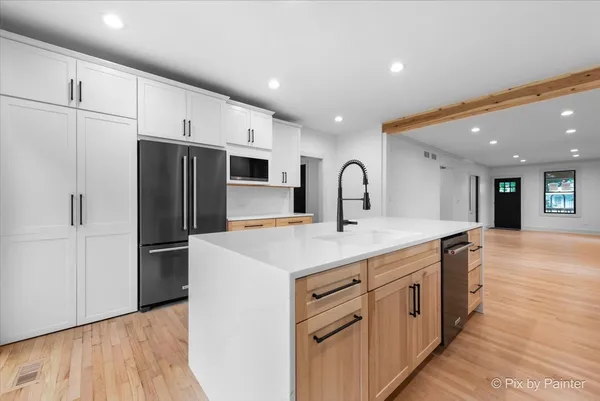 a kitchen with kitchen island a sink stove and refrigerator
