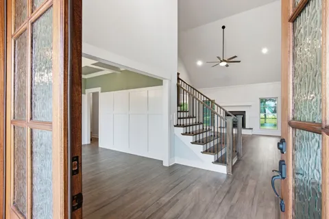 a view of a hallway with wooden floor and staircase