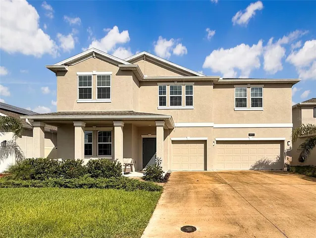 a view of a white house with a yard and plants