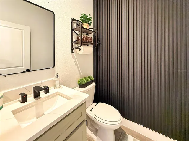 a kitchen with stainless steel appliances granite countertop a stove top oven a refrigerator a sink dishwasher a dining table and chairs with wooden floor