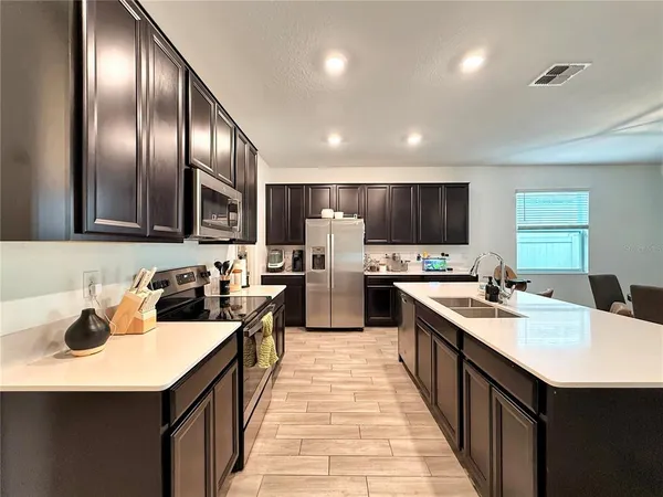 a kitchen with stainless steel appliances a sink a stove a refrigerator and cabinets