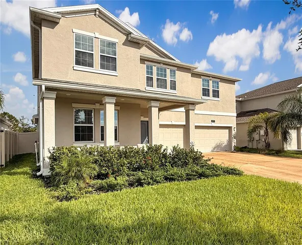 a front view of a house with a yard and garage
