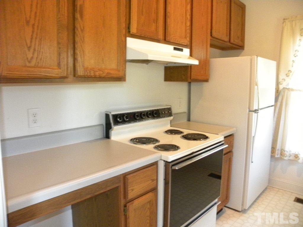1238 Shadow Bark Court Raleigh, NC 27603 - Photo 5 of 17 a kitchen with a sink a stove and a refrigerator