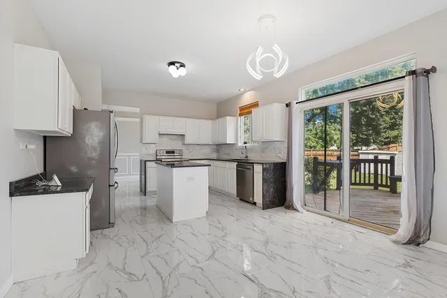a living room with furniture a fireplace and a large window