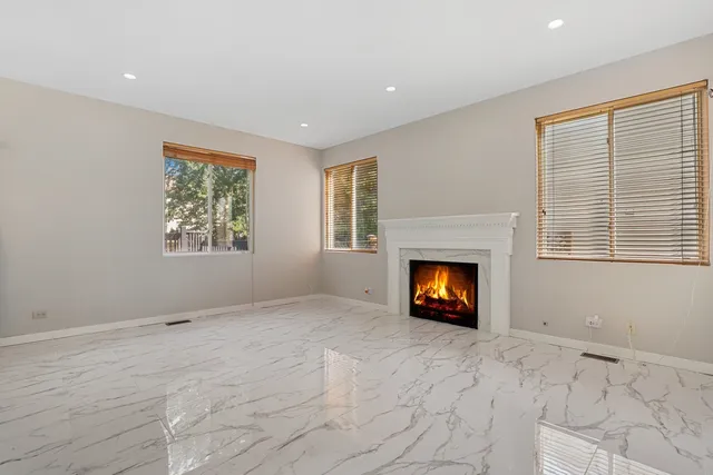 a view of an empty room with a window and fire place