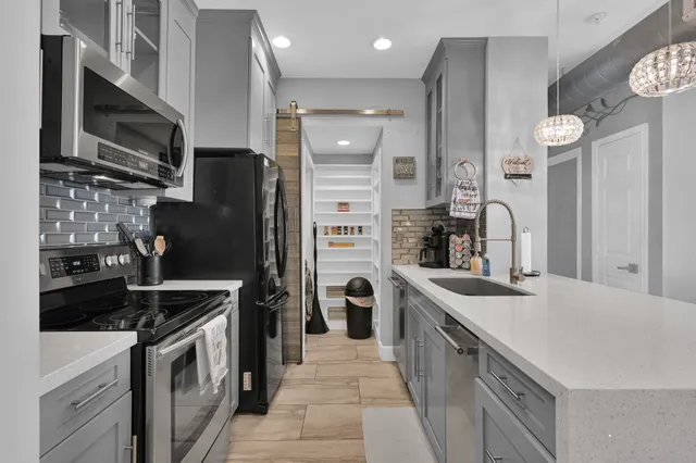 a kitchen that has a sink a stove and a refrigerator