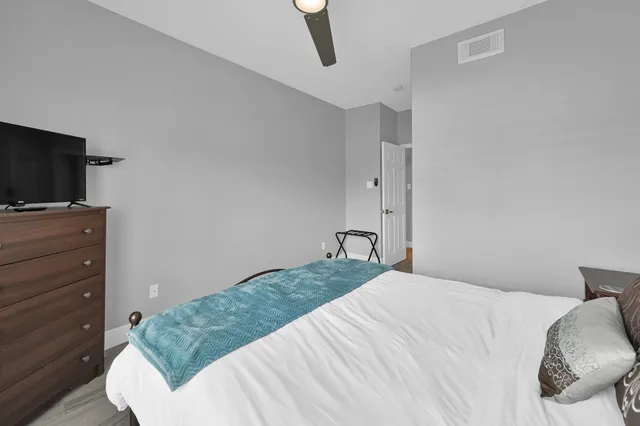 a bedroom with a bed and a tv on the dresser