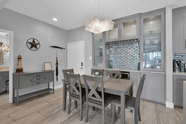 a dining room with stainless steel appliances kitchen island granite countertop a table chairs and a refrigerator
