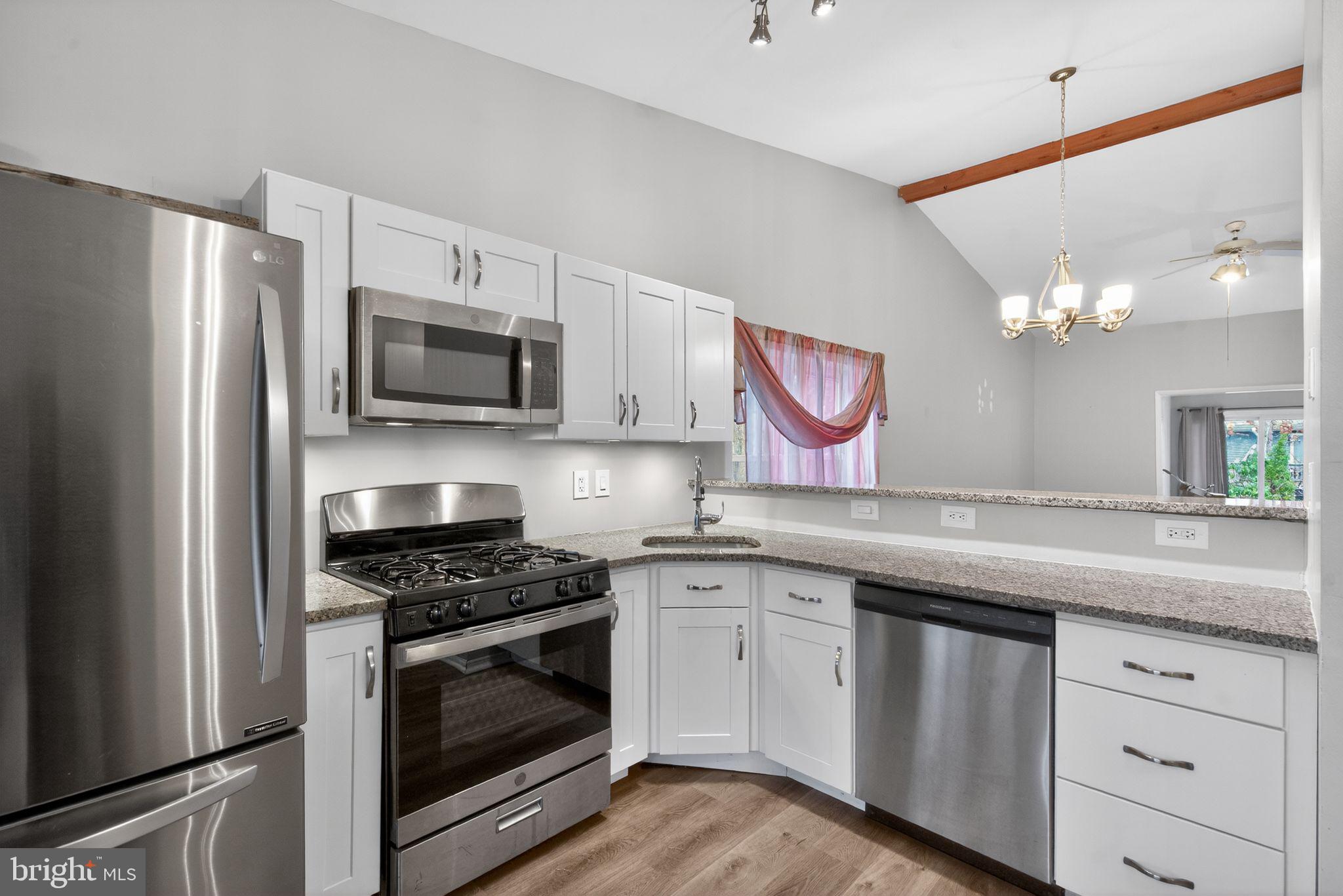 22 Club Place Absecon, NJ 08205 - Photo 6 of 37 a kitchen with granite countertop stainless steel appliances a sink cabinets and a counter top space