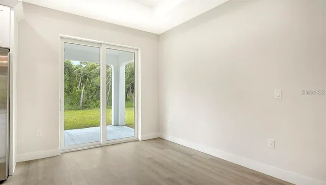 an empty room with wooden floor and sliding door