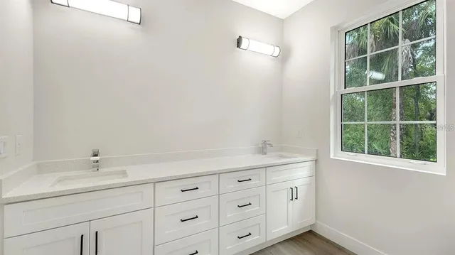a room with a sink cabinets and a window