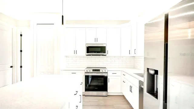 a kitchen with stainless steel appliances a stove microwave and refrigerator