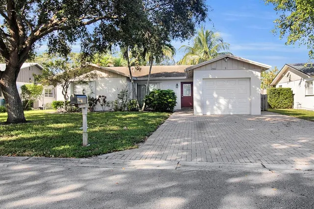 a front view of a house with a yard and trees