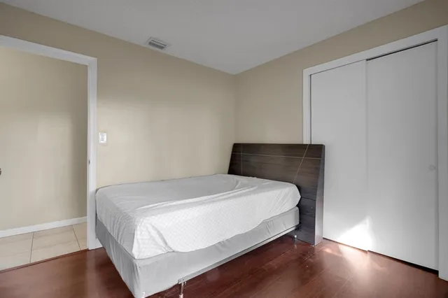 a bedroom with a bed and wooden floor