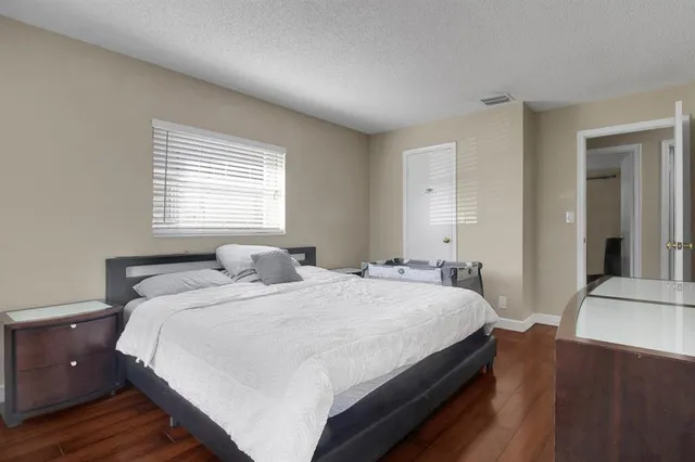 a bedroom with a bed and wooden floor