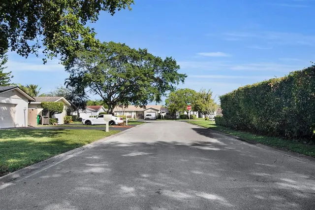 a view of road with houses and trees in the background
