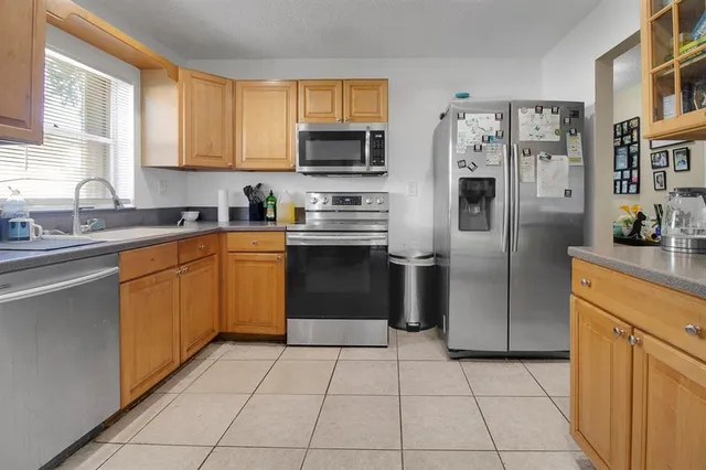 a kitchen with stainless steel appliances granite countertop a refrigerator stove a sink and dishwasher