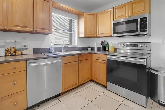 a kitchen with stainless steel appliances granite countertop a stove microwave and sink