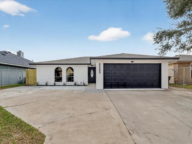 a front view of a house with a garage and a yard