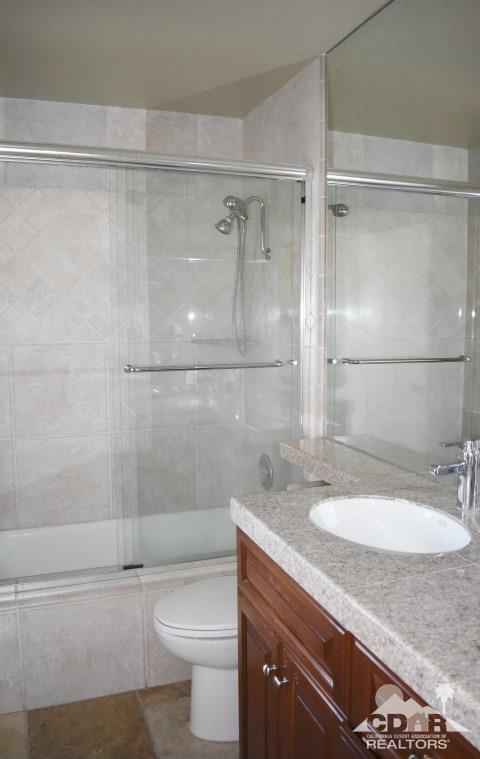 6243 East Driver Road Palm Springs, CA 92264 - Photo 13 of 14 a bathroom with a granite countertop shower sink vanity and toilet