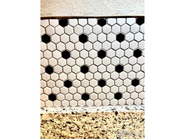 a kitchen with stainless steel appliances kitchen island granite countertop a dining table chairs and a refrigerator