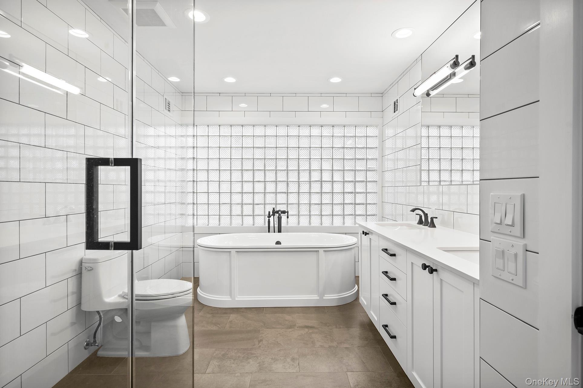 1 Acorn Path Quogue, NY 11959 - Photo 16 of 24 a bathroom with a double vanity sink toilet and shower