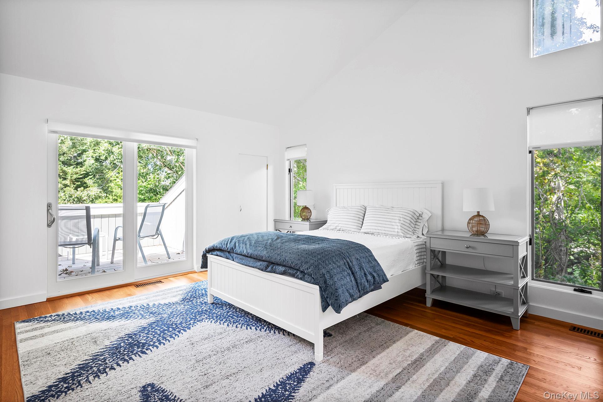 1 Acorn Path Quogue, NY 11959 - Photo 19 of 24 a spacious bedroom with a bed and wooden floor