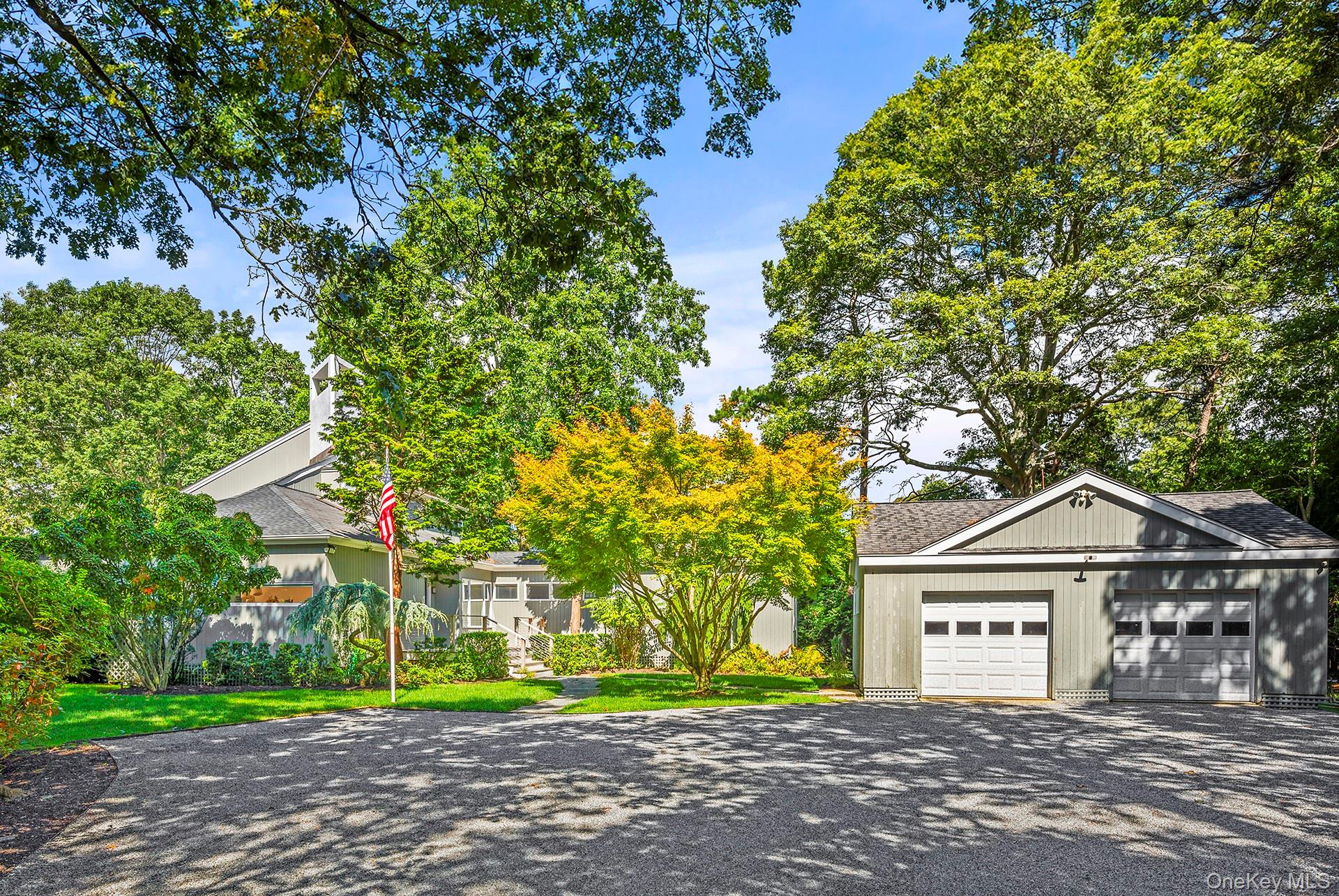 1 Acorn Path Quogue, NY 11959 - Photo 4 of 24 a front view of a house with a yard and garage