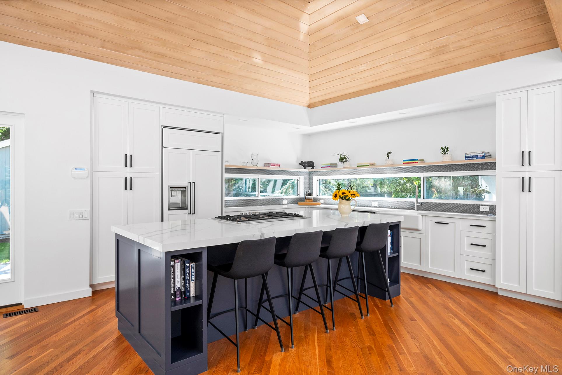 1 Acorn Path Quogue, NY 11959 - Photo 10 of 24 a kitchen with stainless steel appliances a table chairs in it and wooden floors