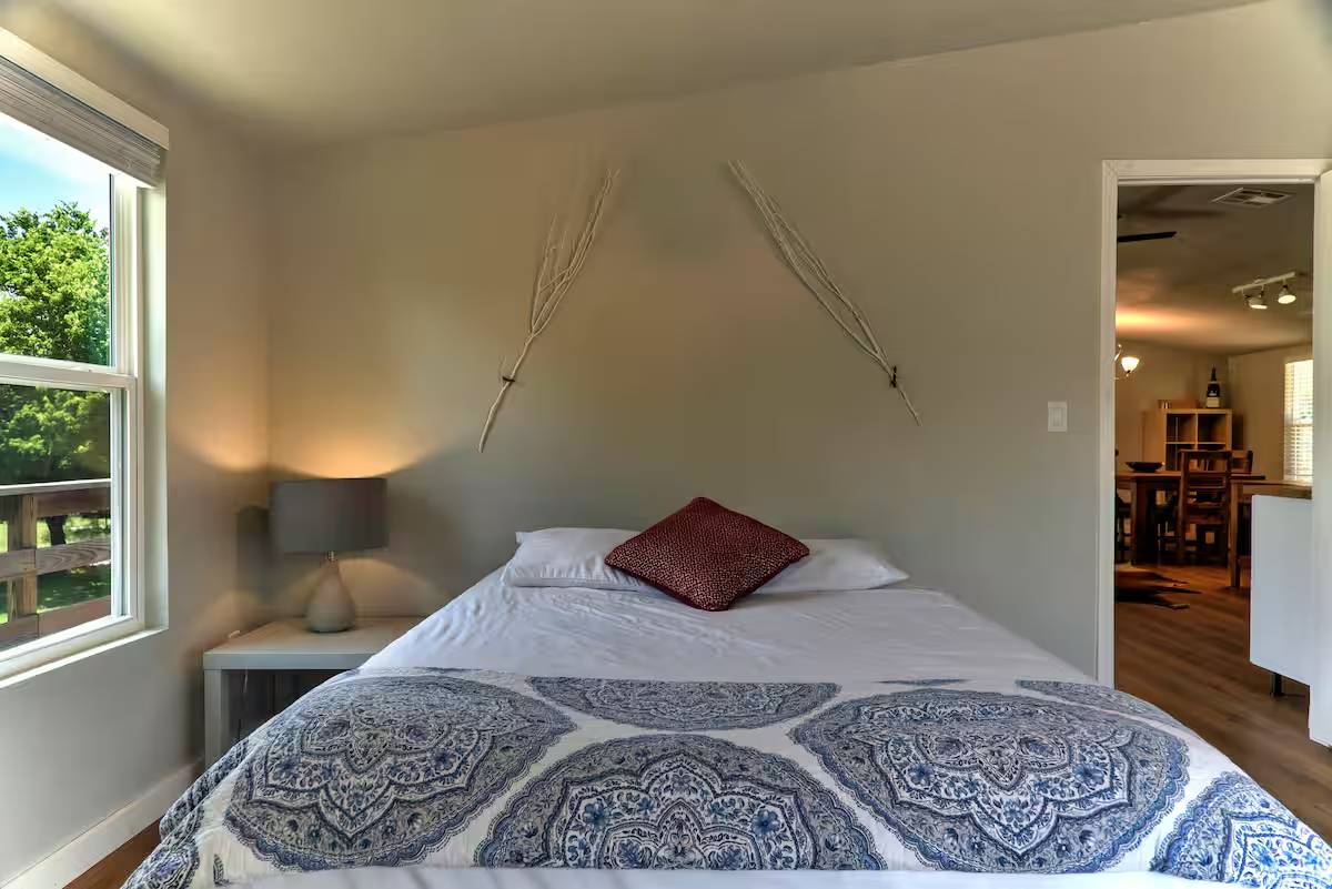 8807 High Valley Road Austin, TX 78737 - Photo 13 of 22 A well-lit bedroom with a view of the outdoors, offering a comfortable and serene retreat.