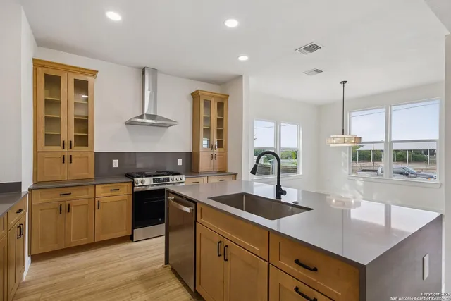 a kitchen with stainless steel appliances granite countertop a sink stove and cabinets