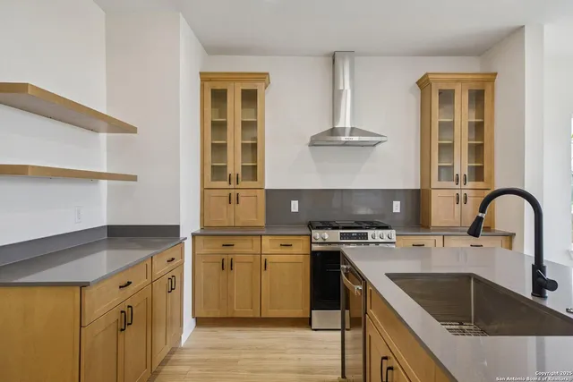 a kitchen with stainless steel appliances granite countertop a stove a sink and a microwave