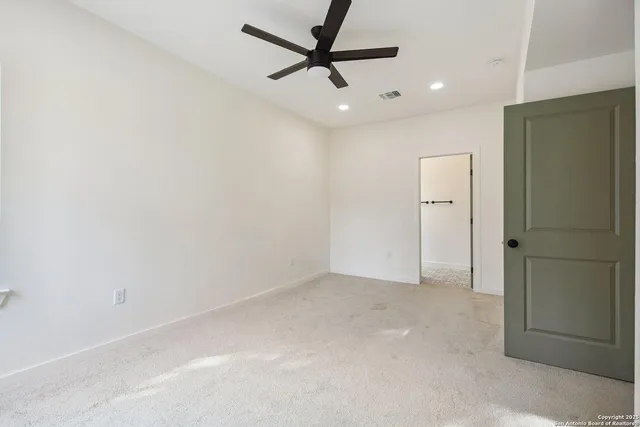 an empty room with closet and fan
