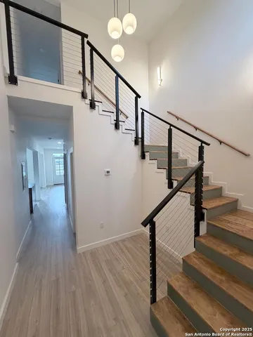 a view of staircase with wooden floor and a chandelier