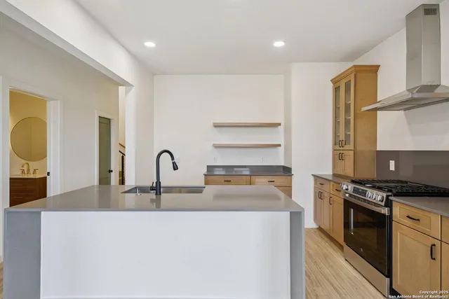 a kitchen with kitchen island granite countertop a stove and a sink
