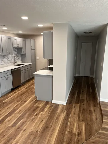 a view of a kitchen with wooden floor and electronic appliances