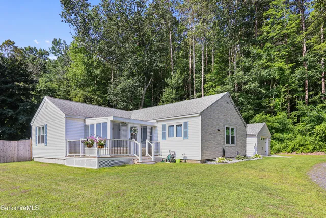 a front view of a house with a garden and trees