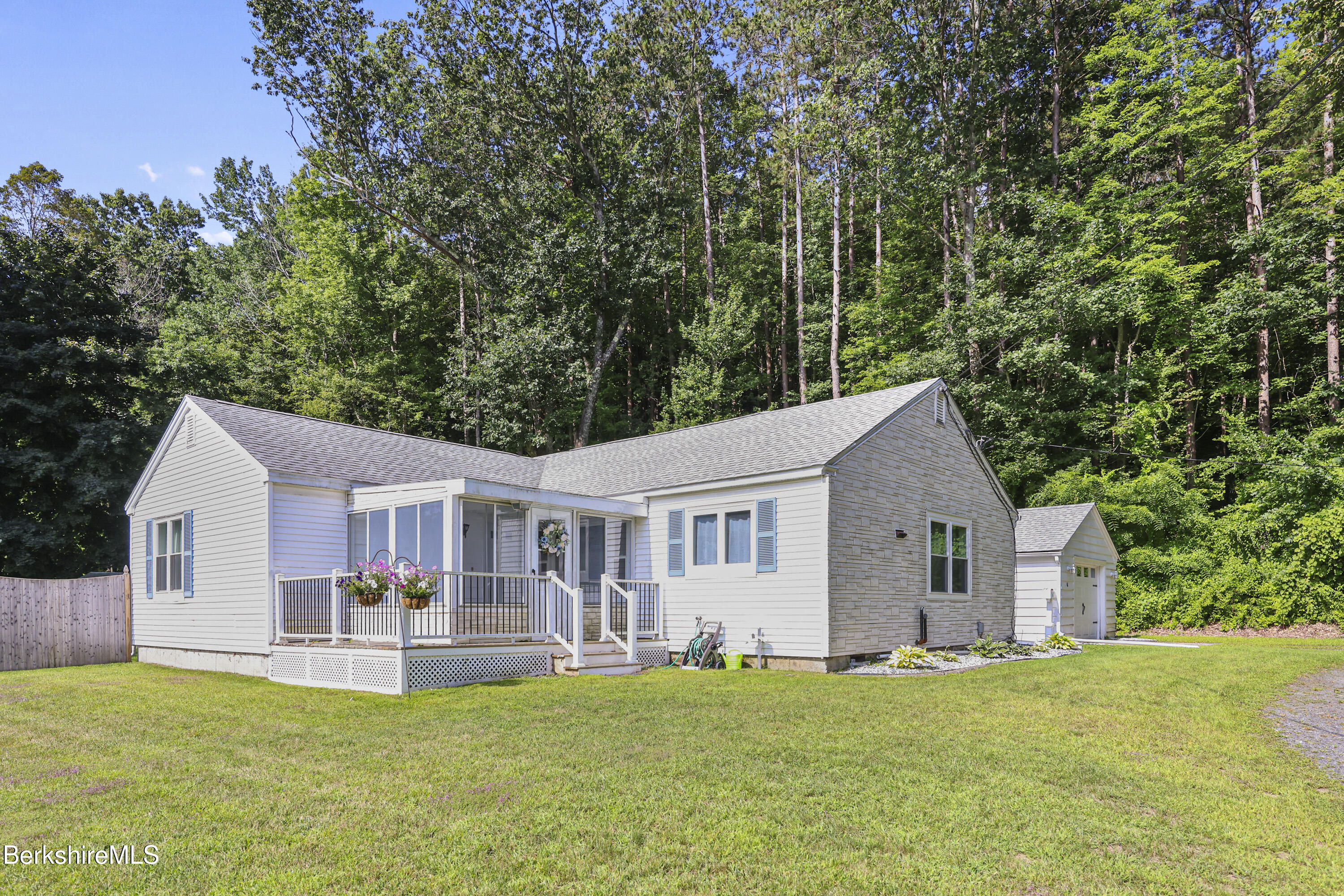 a front view of a house with a garden and trees