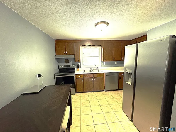 a large kitchen with a stove a refrigerator and a sink