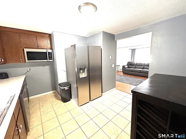 a kitchen with stainless steel appliances kitchen island granite countertop a refrigerator and a stove top oven