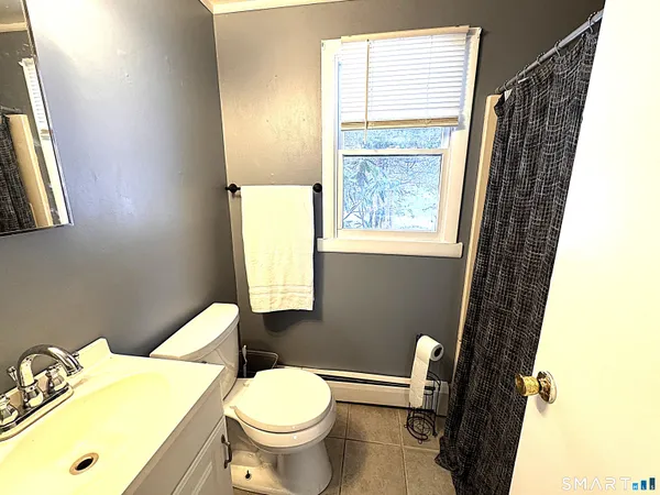 a bathroom with a sink toilet and window
