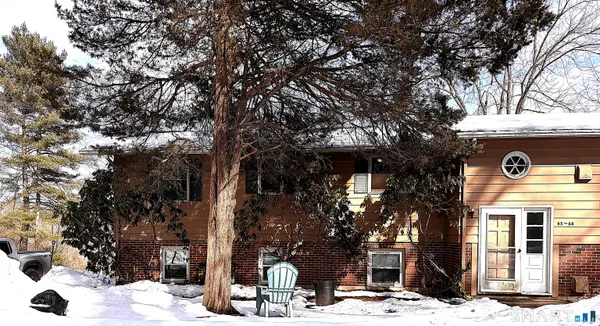 a front view of a house with a tree