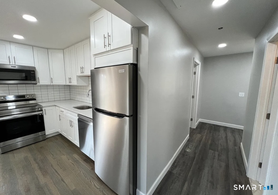 270 R East Street Plainville, CT 06062 - Photo 7 of 28 a kitchen with a refrigerator a stove top oven and wooden floor
