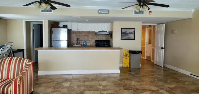 a view of kitchen with stainless steel appliances granite countertop living room