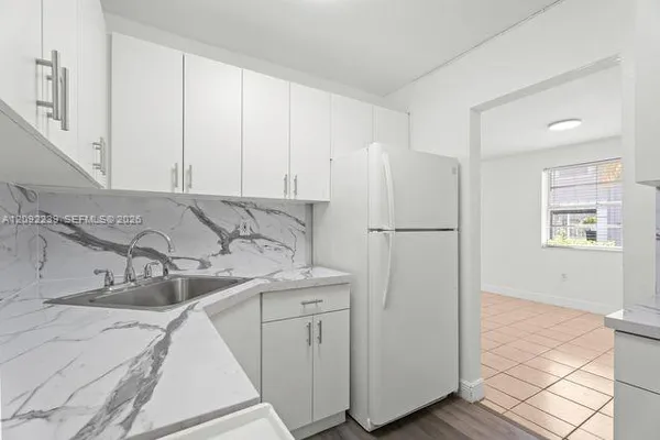a white refrigerator freezer sitting inside of a kitchen