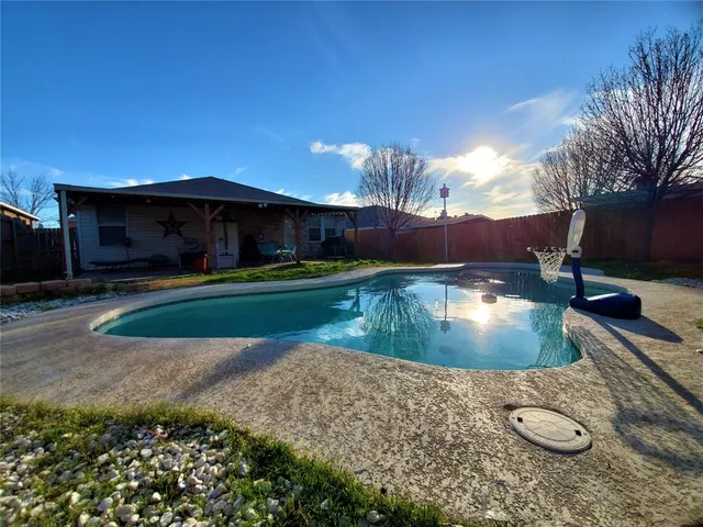 a view of a backyard with swimming pool