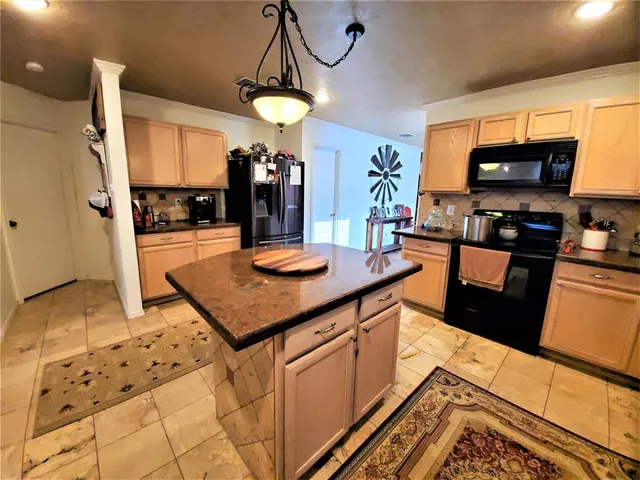 a kitchen with stainless steel appliances a stove a sink a microwave and refrigerator