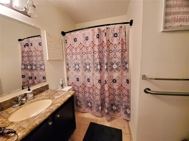 a bathroom with a granite countertop sink a toilet and shower
