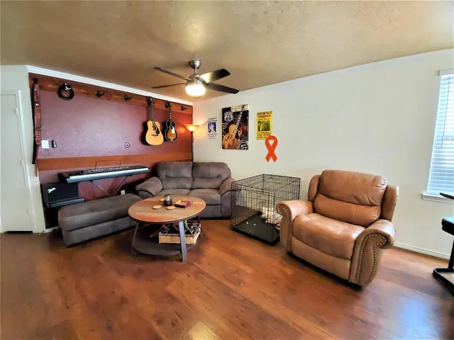 a living room with furniture a wooden floor and a large window