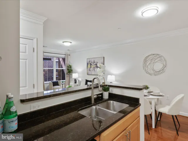 a kitchen with a sink and a stove with wooden floor